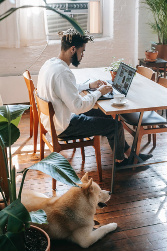 A business owner works from his home while sitting at a table.