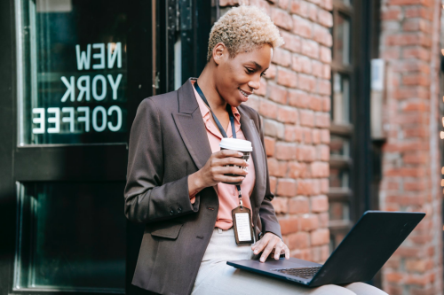 A woman works out of a cafe while using her laptop.